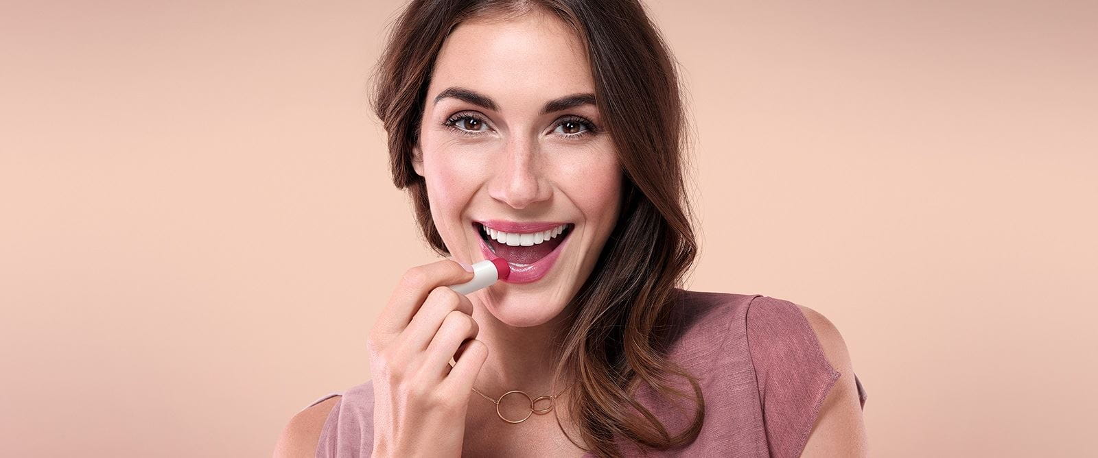 mulher a colocar batom do cieiro com cor