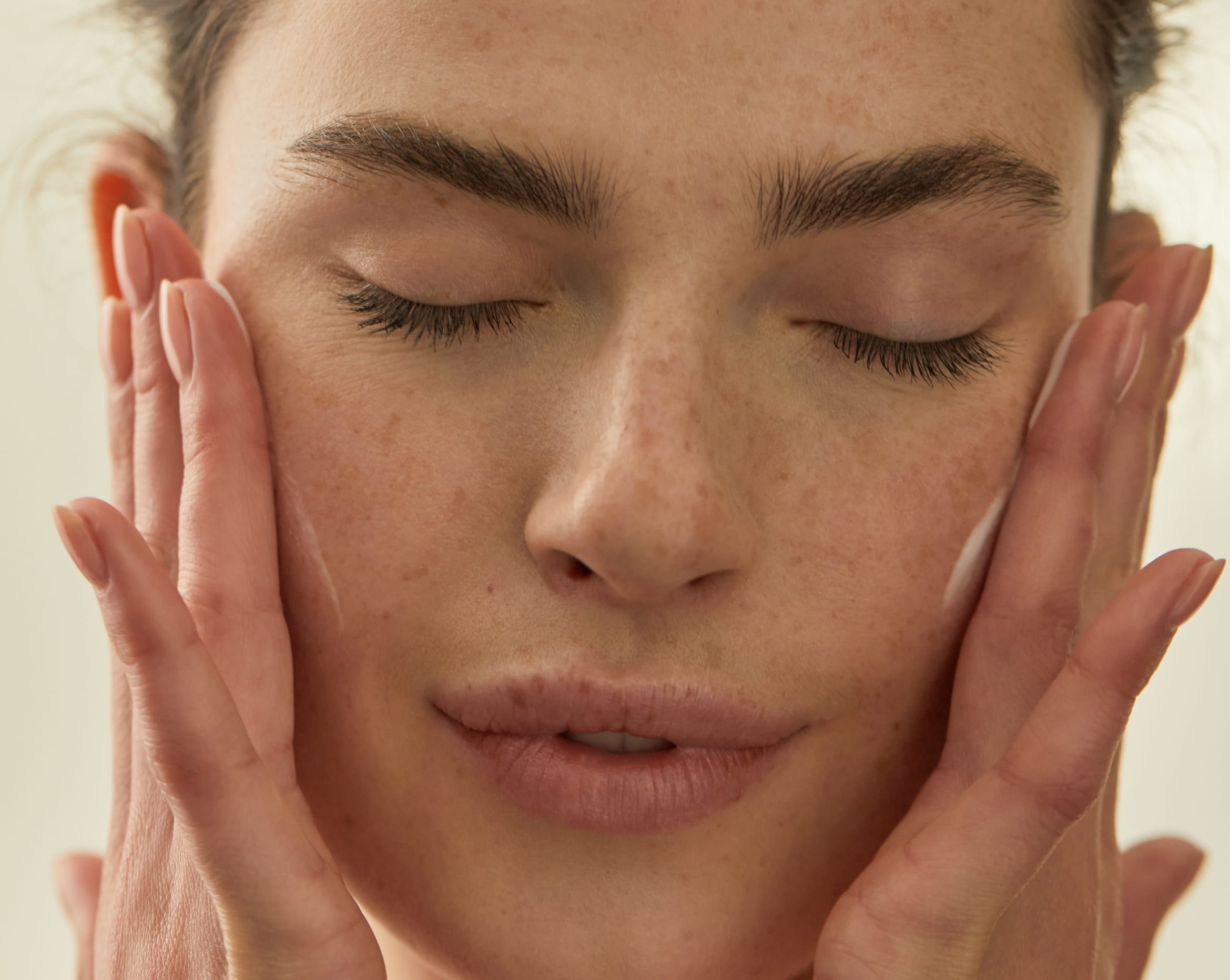 kvinna blundar och har händerna på sina kinder