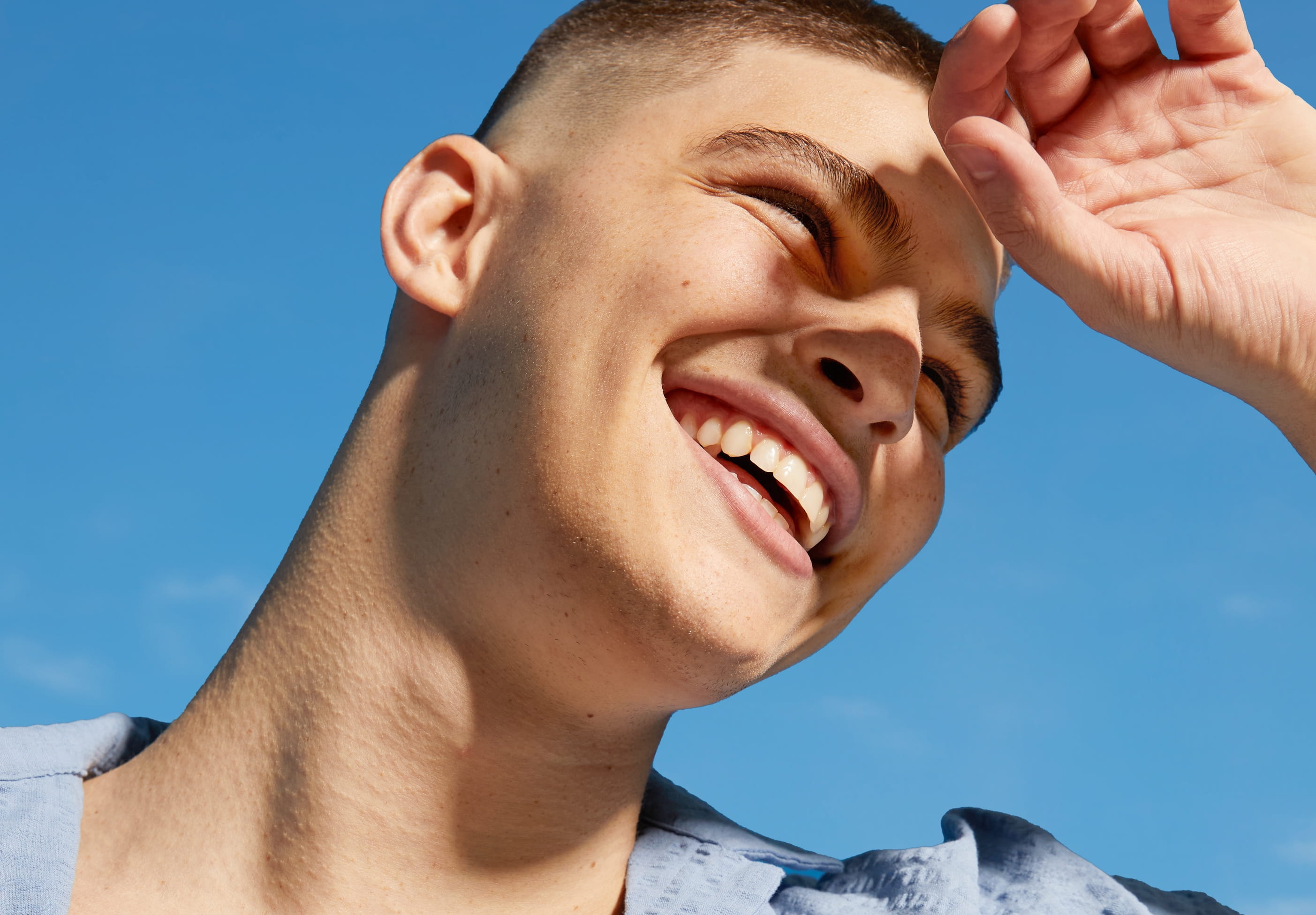 En person som han ena handen mot pannan för att täcka solen för att se bättre.