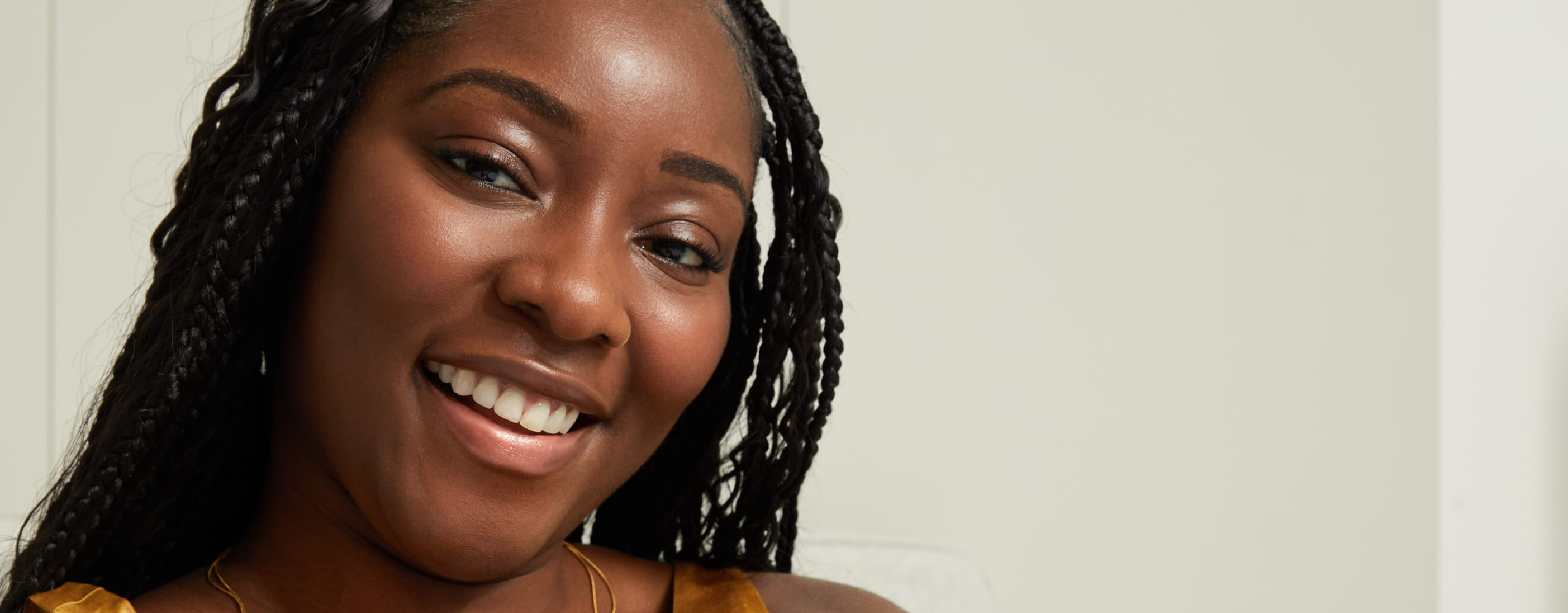 Jeune femme noire utilisant le sérum-lotion raffermissant et énergisant pour le corps Q10