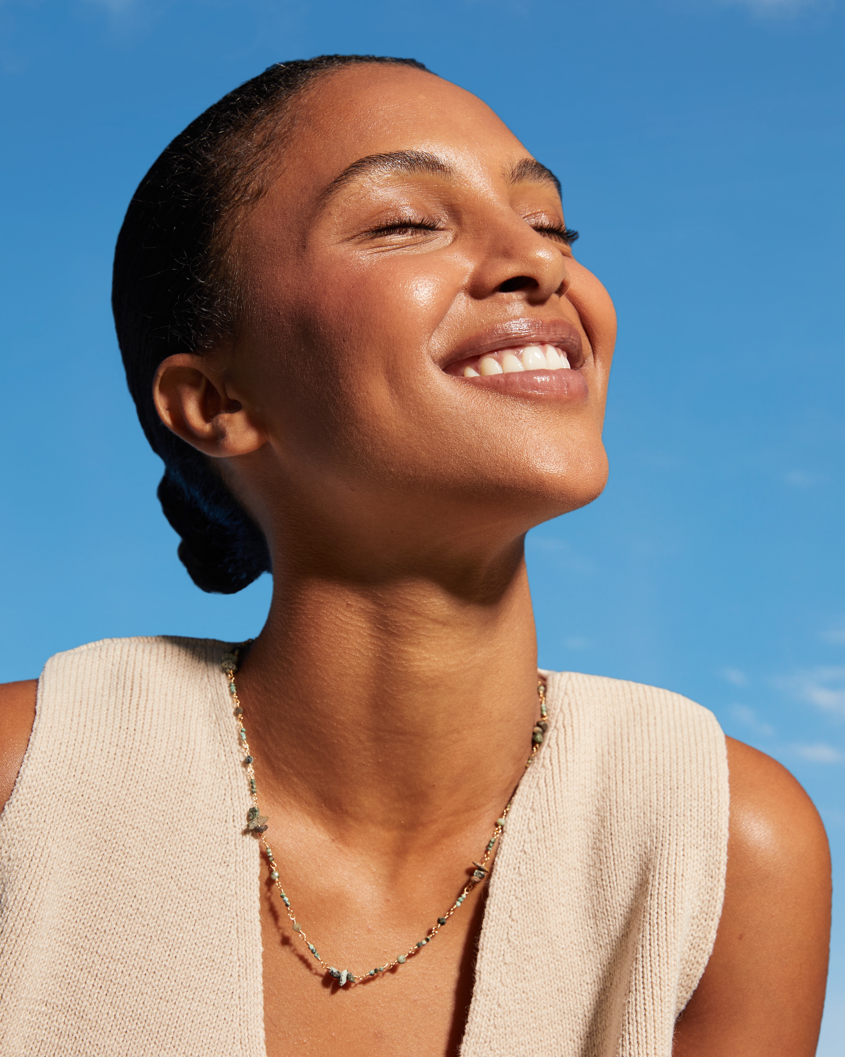 En person som har slutna ögon och vänder sig mot solen