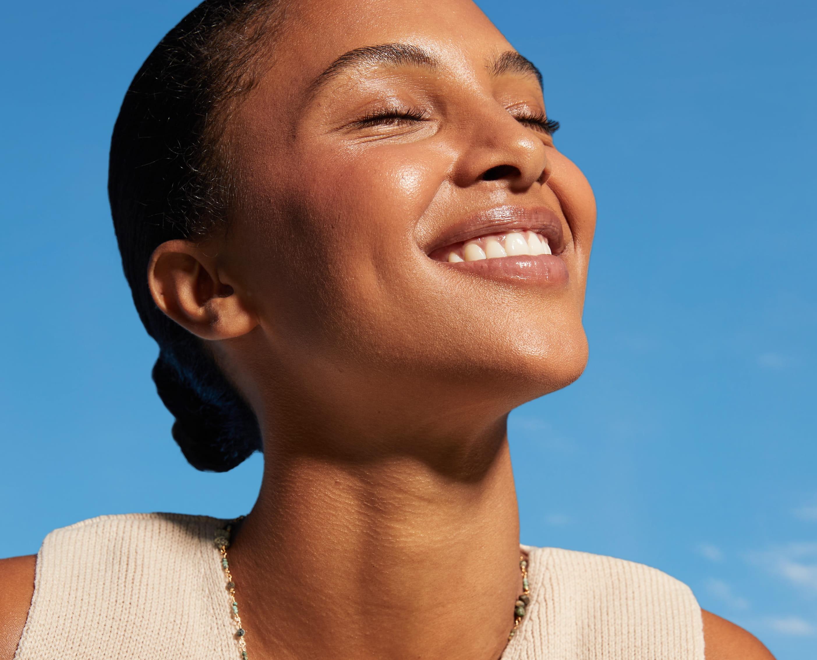 En person som har slutna ögon och vänder sig mot solen