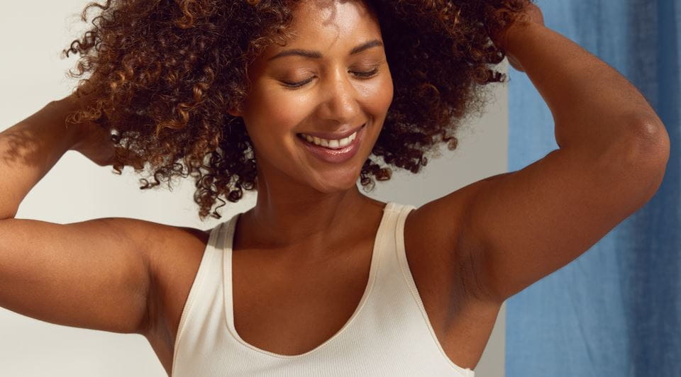 Femme nue sur sofa se couvre avec un pull