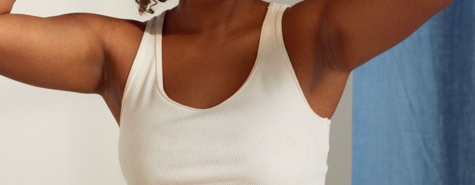 Femme nue sur sofa se couvre avec un pull