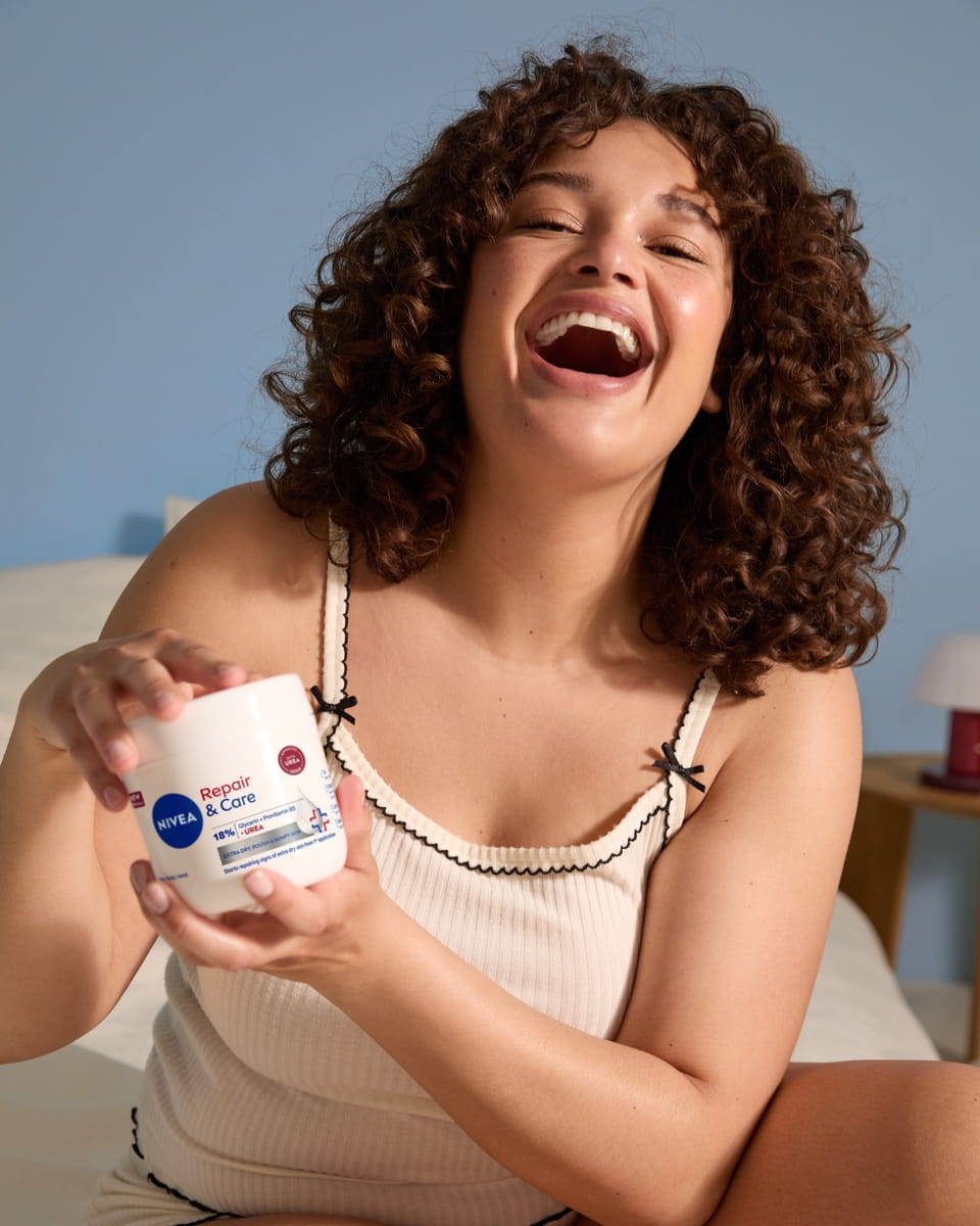 Fiatal nő NIVEA Repair and Care krémet használ