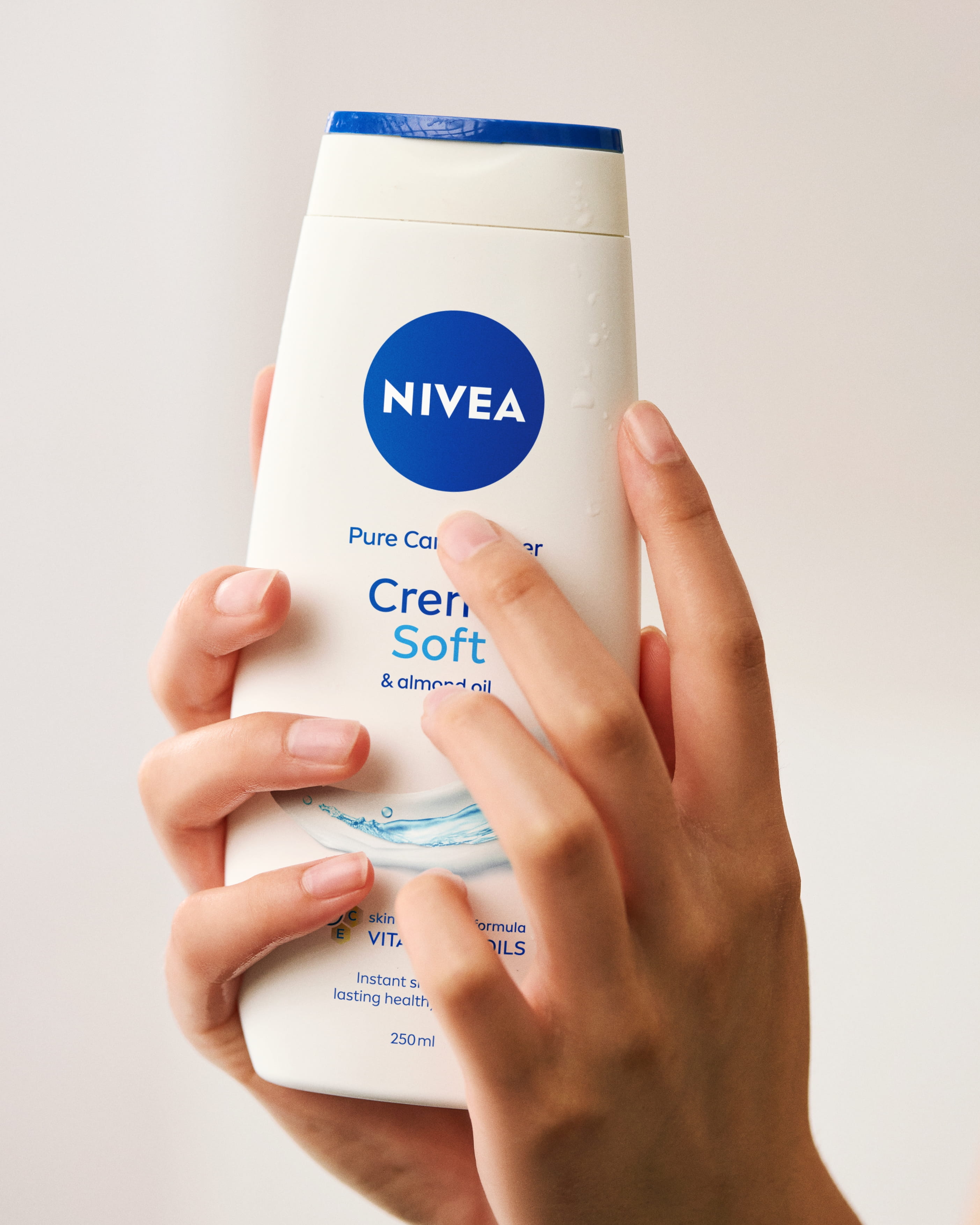 Händer som håller i NIVEA soft duschkräm