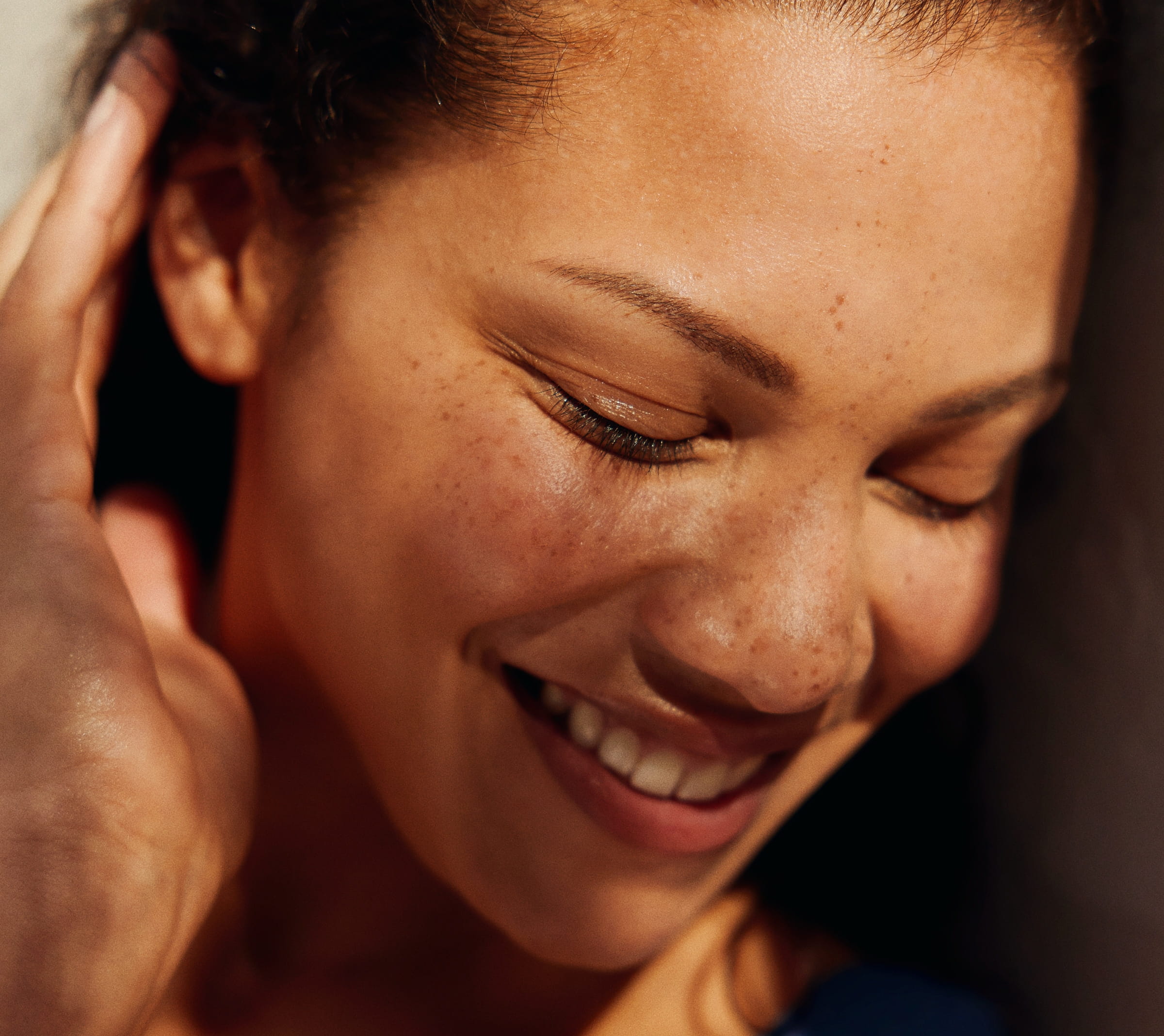 A close-up of a smiling woman with curly hair