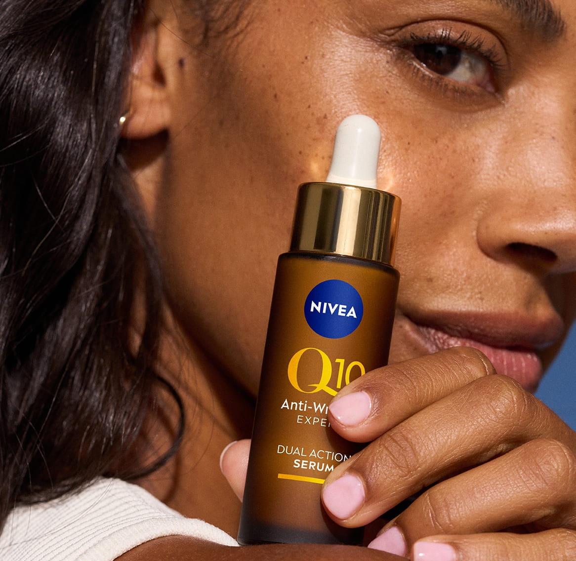 Giovane donna che utilizza il siero doppio effetto antirughe NIVEA Q10 Anti-Wrinkle Expert