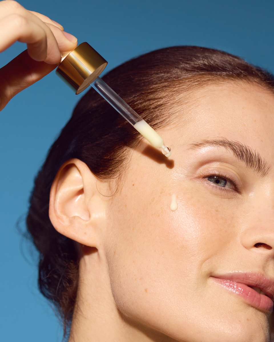 Vrouw die gezichtsserum aanbrengt