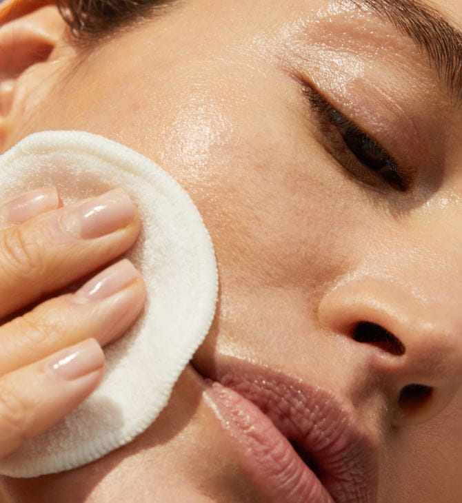 woman cleaning her face