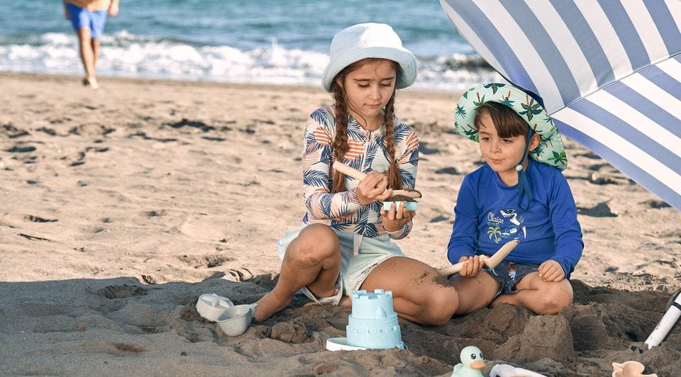 Baby met hoedje op strand