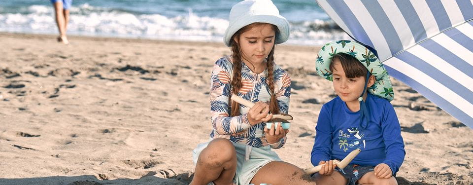 Baby met hoedje op strand
