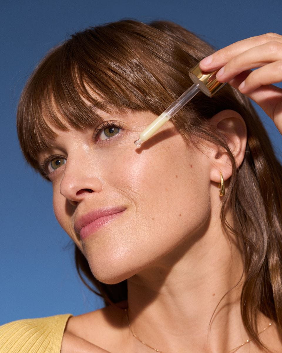 Eine junge Frau trägt ein Gesichtsserum auf