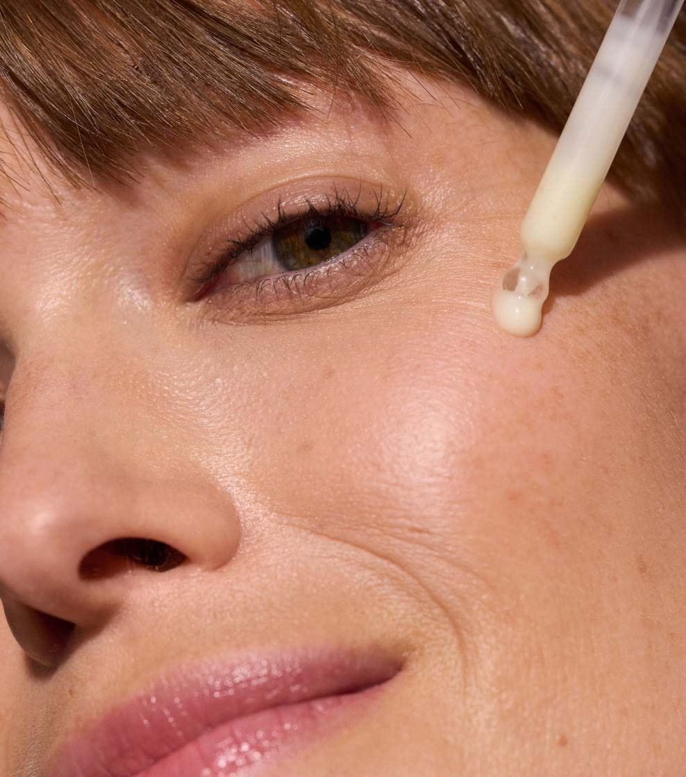 "A close-up shot of a woman applying NIVEA Q10 ANTI-WRINKLE SPECIALIST DUAL ACTION SERUM on deep wrinkles around the eyes. "