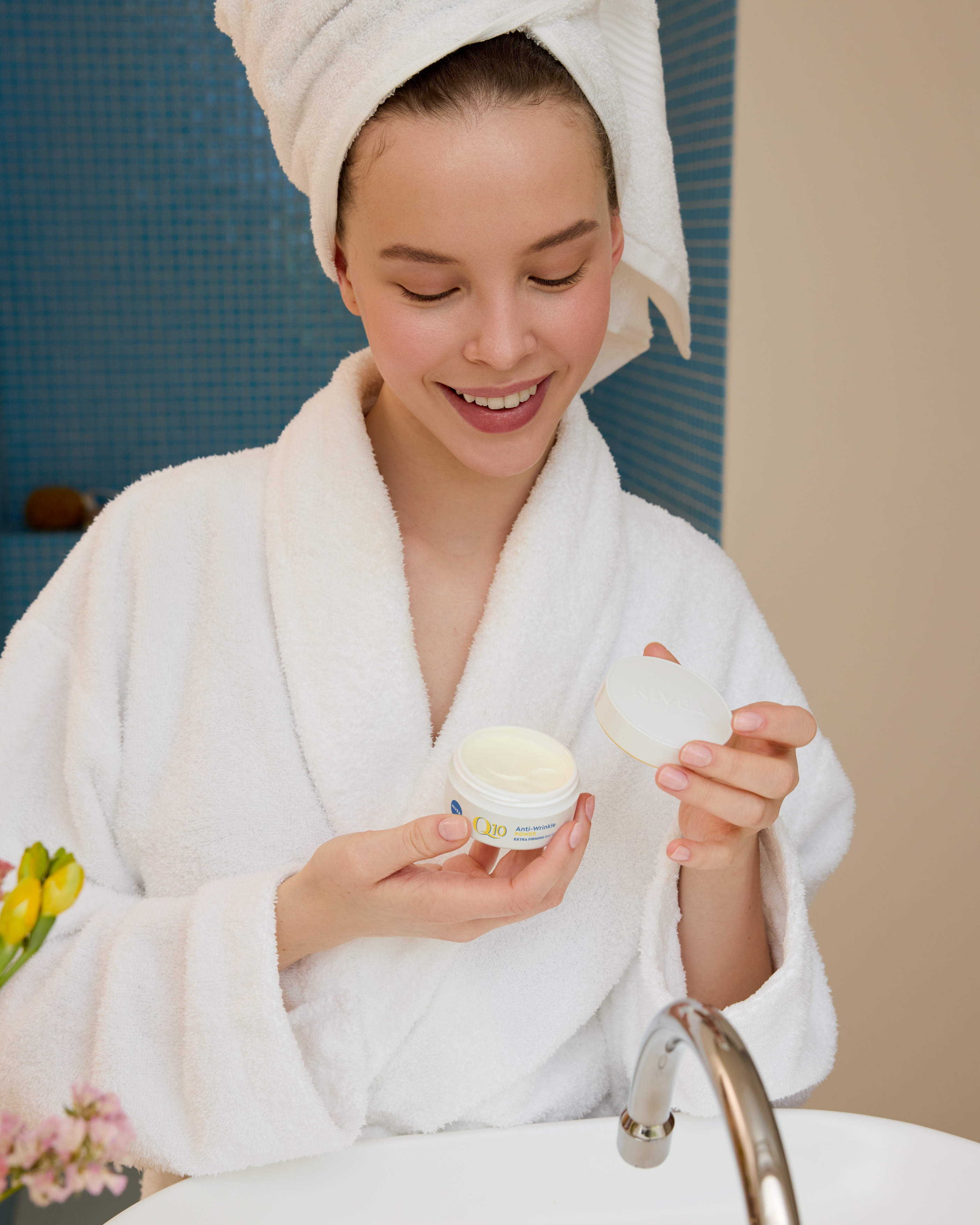 kvinna som håller i Nivea Q10 ansiktskräm