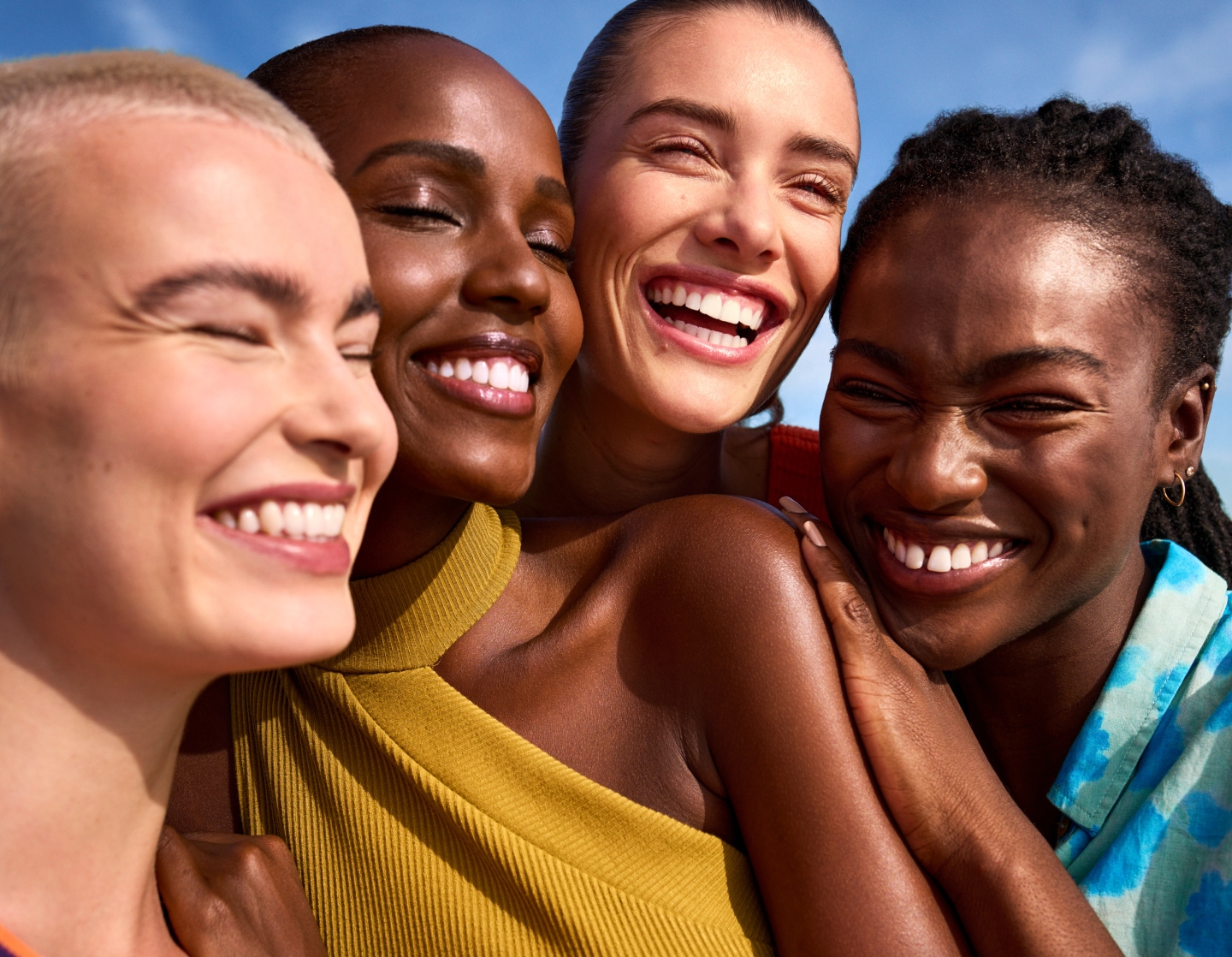 Cuatro personas posando y sonriendo con su piel radiante