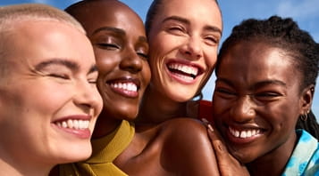 Cuatro personas posando y sonriendo con su piel radiante