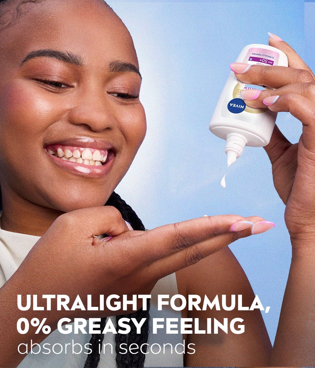 Young woman smiles excitedly as she dispenses NIVEA LUMINOUS630® SKIN GLOW Instant Glow Fluid SPF 50+ onto her fingers.