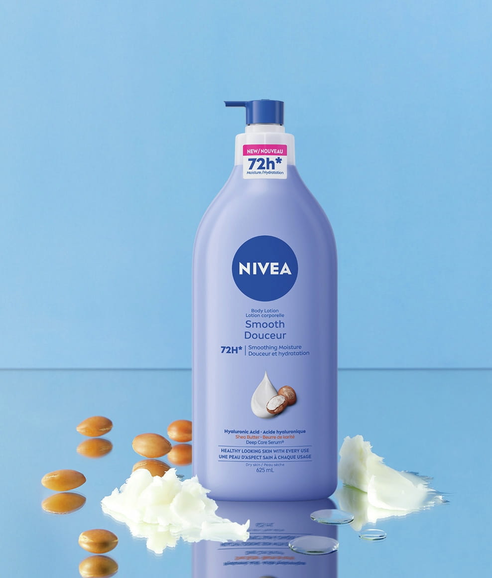 A image of NIVEA Smooth Body Lotion. It is surrounded by rich swirls of white lotion representing shea butter and scattered golden-brown nuts.