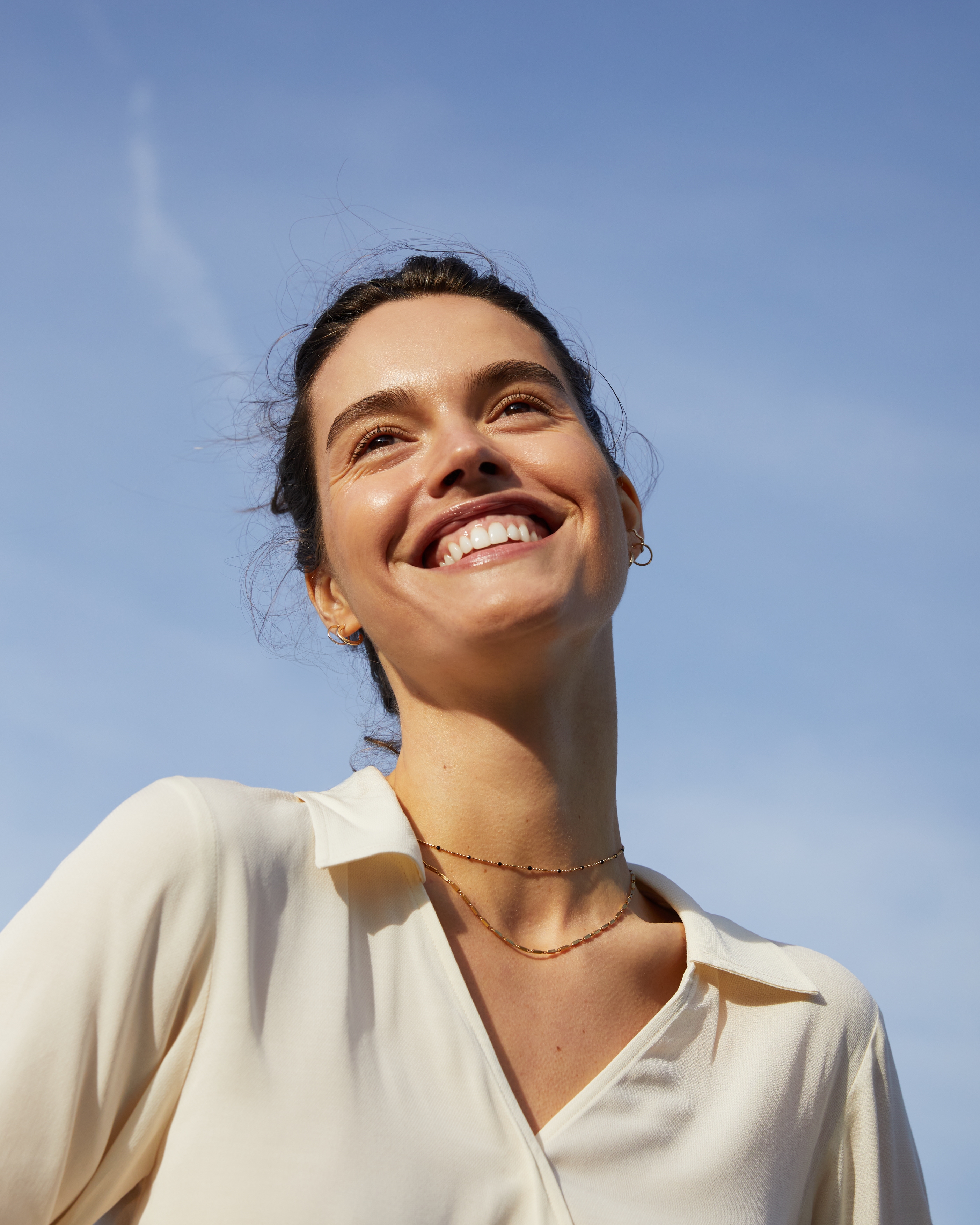 En person som ler och tittar upp i himlen