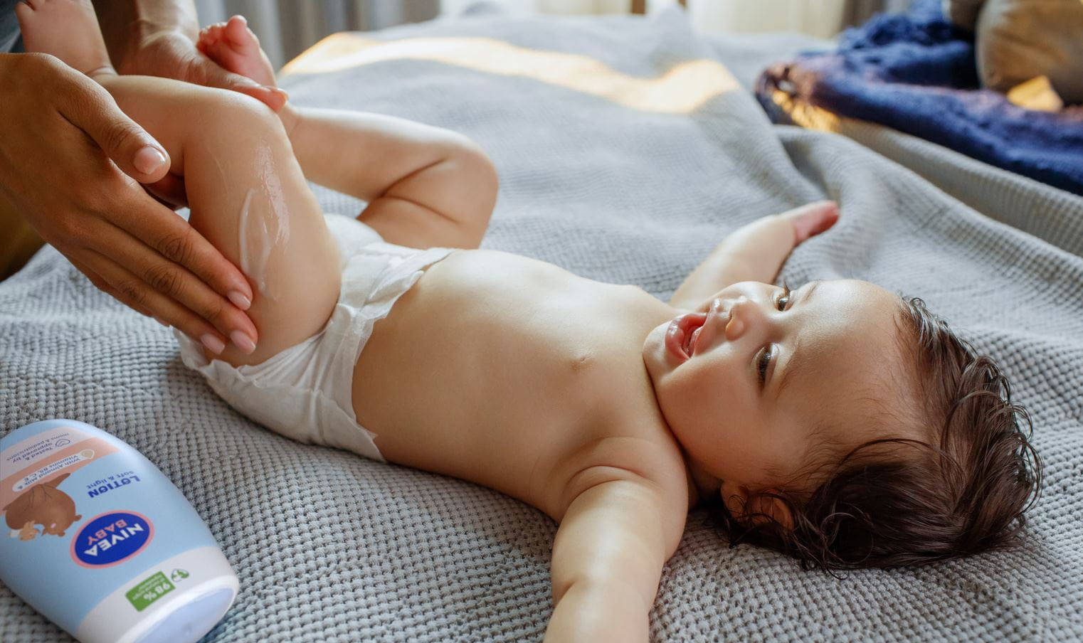 Eine Mutter trägt Babycreme auf