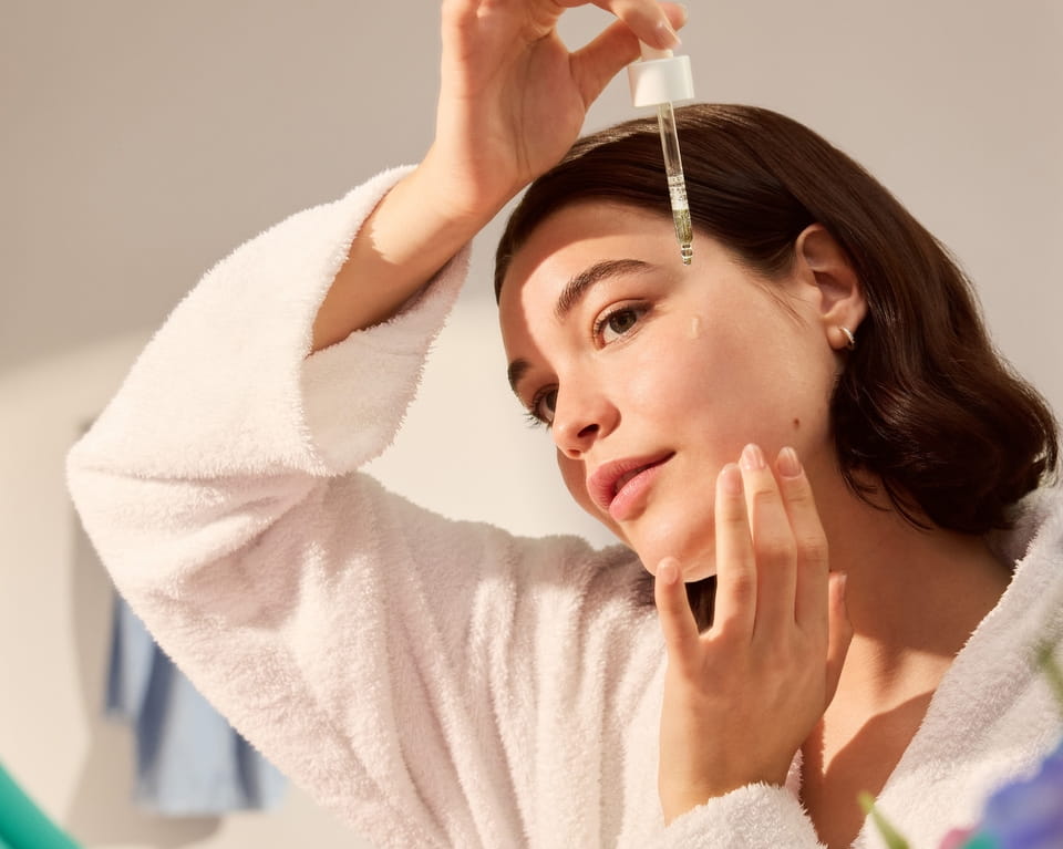 νεαρή γυναίκα που εφαρμόζει ορό Nivea