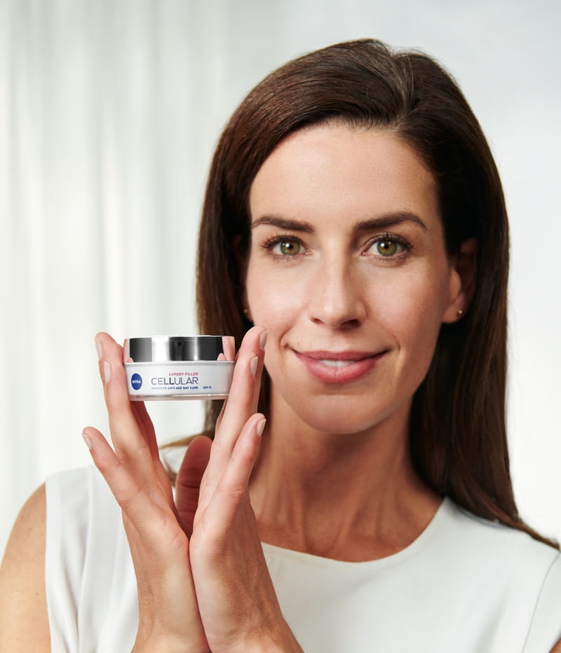Vrouw die NIVEA Cellular Expert Filler Intensive Anti-Age Dagcrème SPF 15 gebruikt