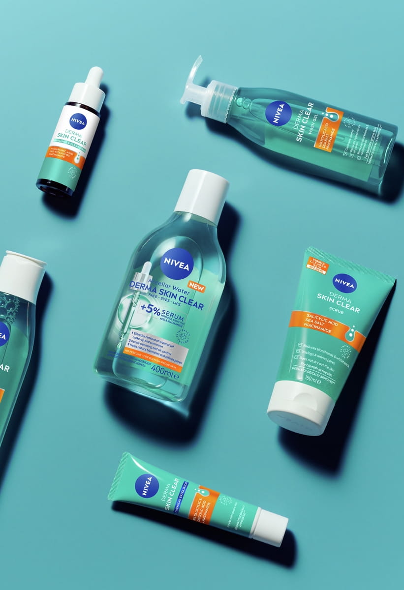 Produits de soin pour la peau Nivea Derma Skin Clear présentés sur un fond turquoise