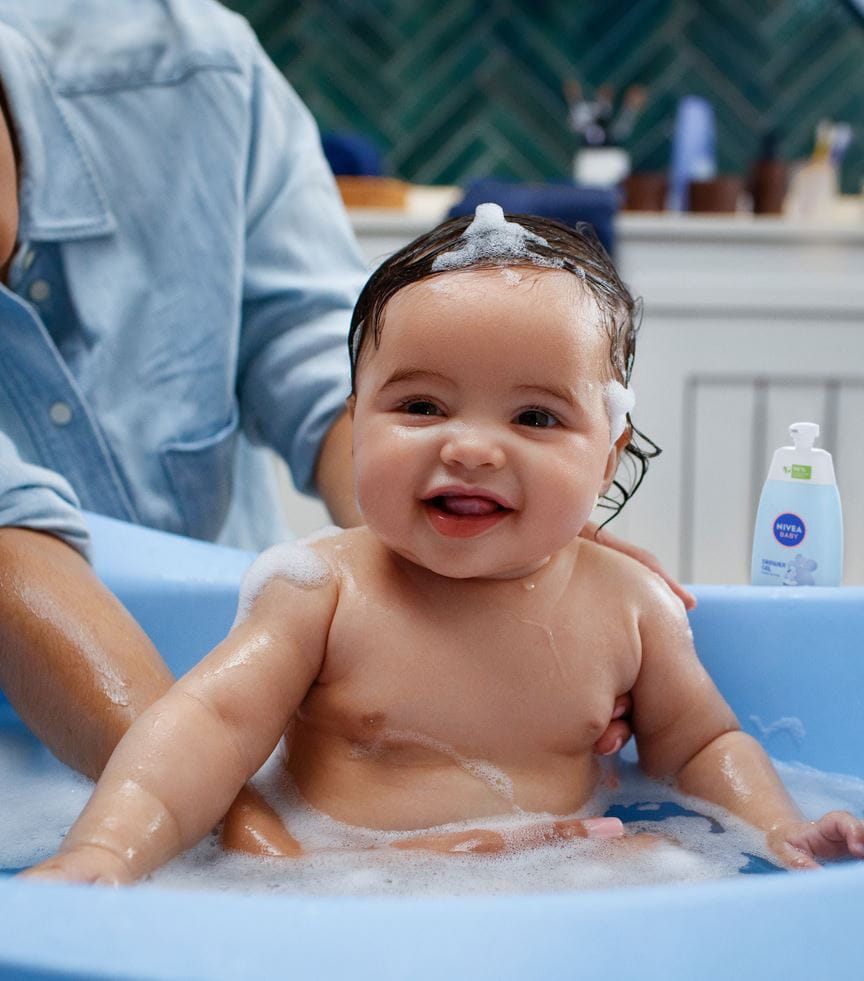 Glückliches Baby, das ein Bad nimmt