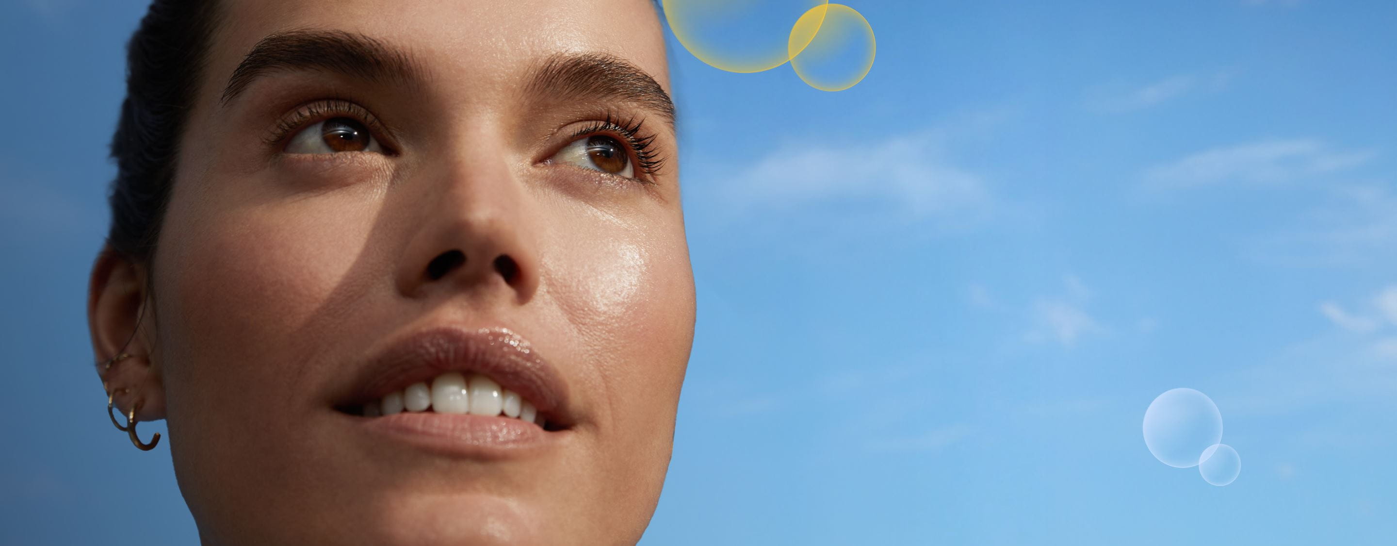 Γυναίκα με τζίντζερ μαλλιά που κρατάει μια κρέμα προσώπου Nivea Q10