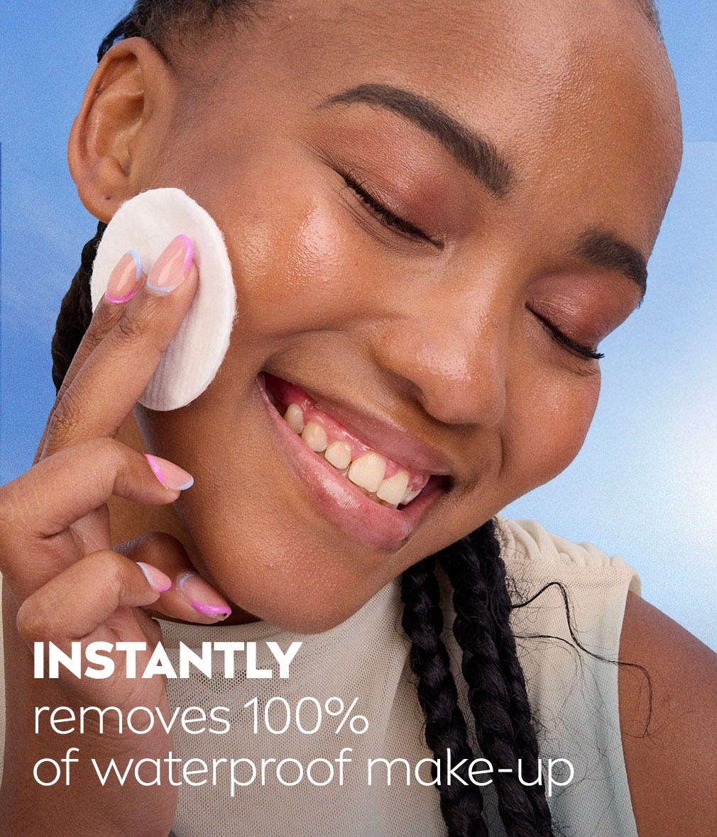 Young woman smiles with closed eyes, holding up a cotton pad to her face, with text about removing 100% of waterproof make-up.