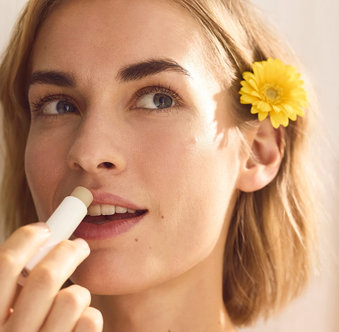 Młoda kobieta używająca balsamu do ust Nivea Special Pride Edition