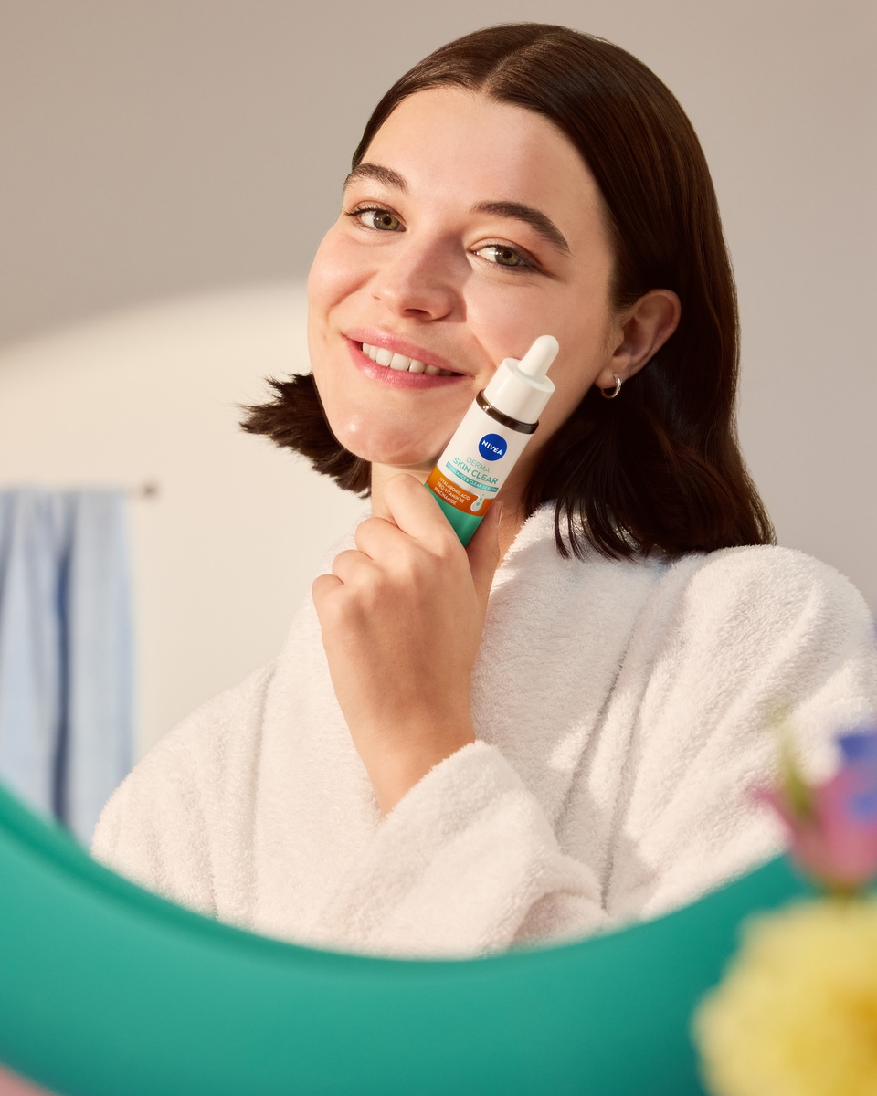 Junge Frau, die NIVEA Derma Skin Clear Rebalance & Clear Serum verwendet