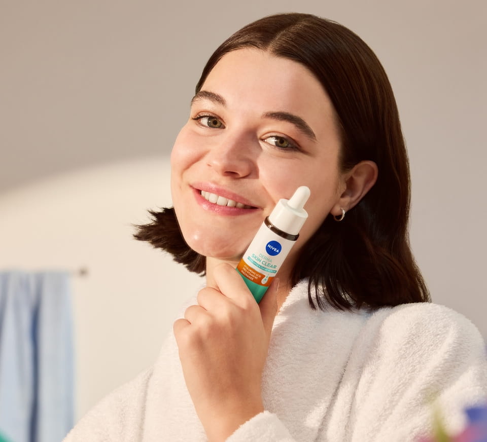 Jonge vrouw die NIVEA Derma Skin Clear Rebalance & Clear Serum gebruikt