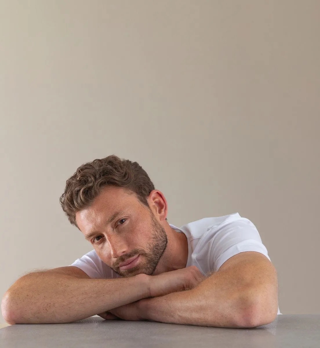 man zit met zijn arm gekruist