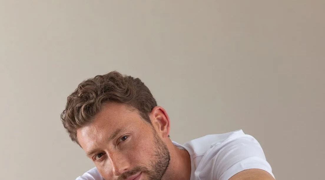 man zit met zijn arm gekruist