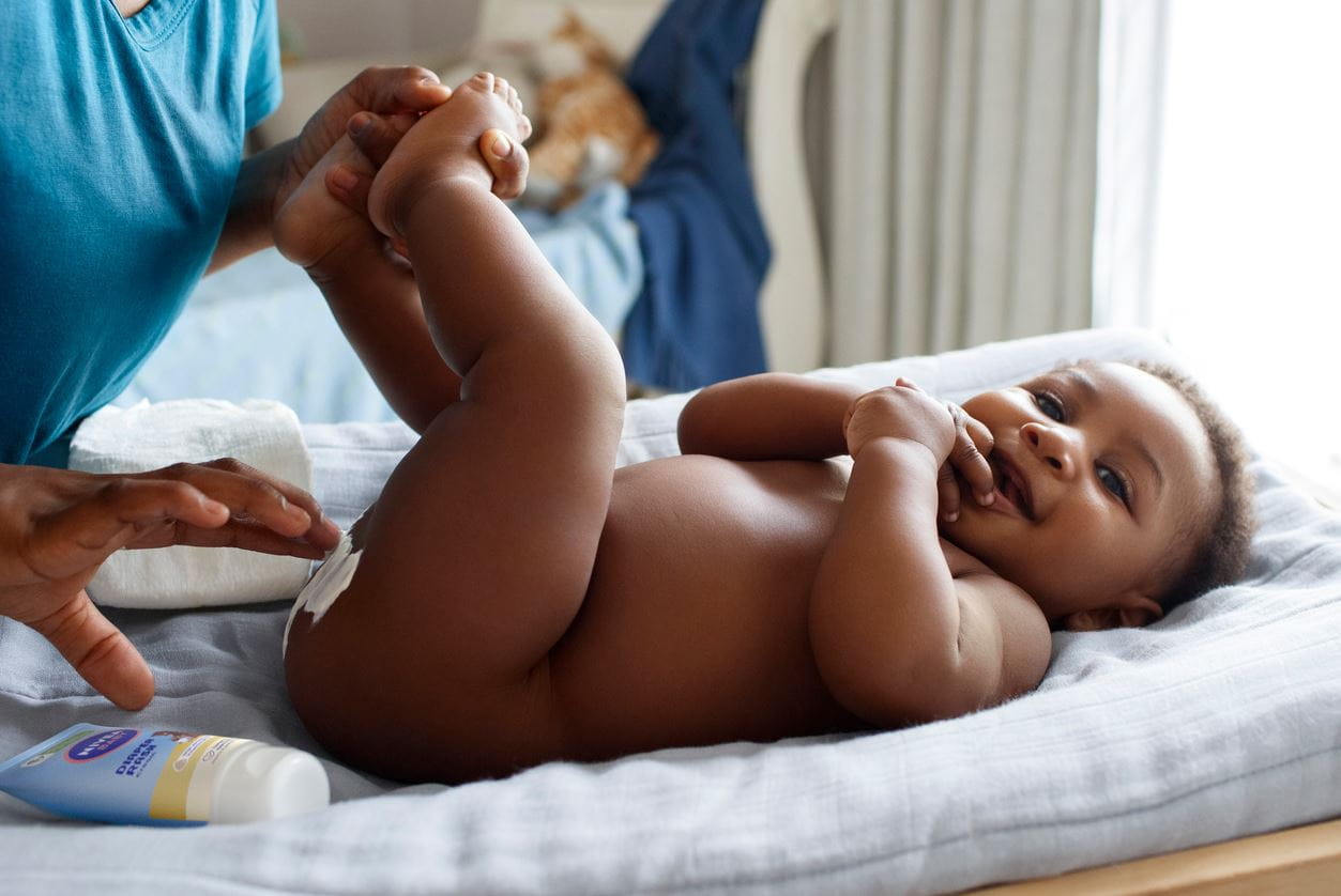 Eine Mutter wechselt die Windel ihres Babys