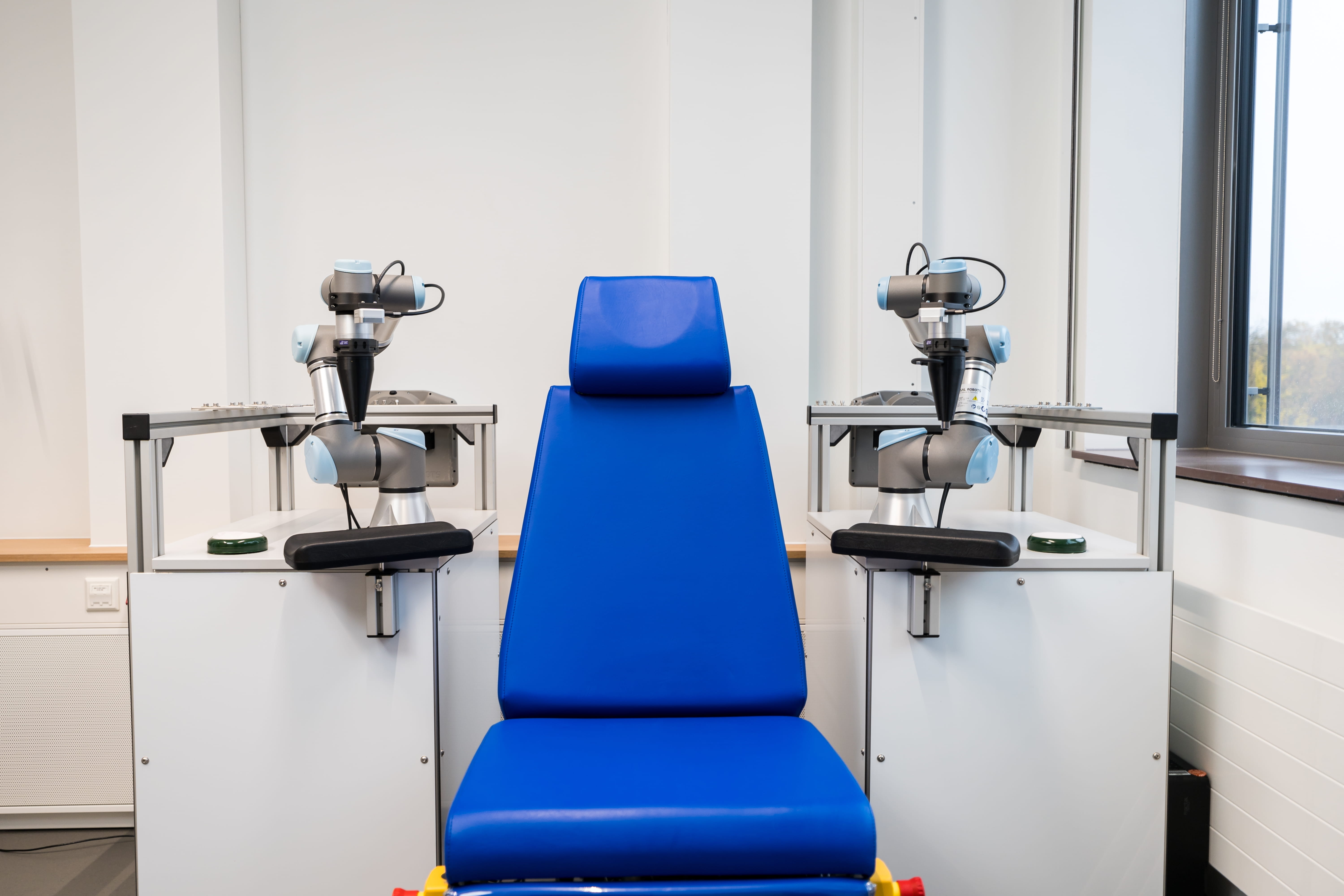 Blue chair with robotic arms in a laboratory setting.