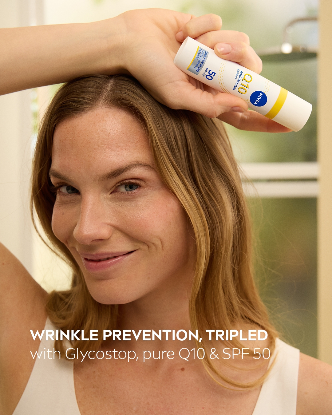 Nuori nainen käyttää Nivea Q10 Anti Wrinkle Expert SPF 50 -tuotetta.