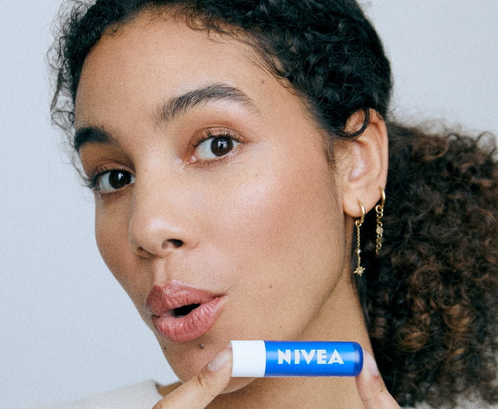 Młoda kobieta używająca balsamu do ust Nivea