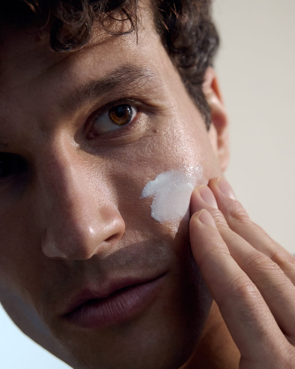man touching his close shave while looking in the mirror