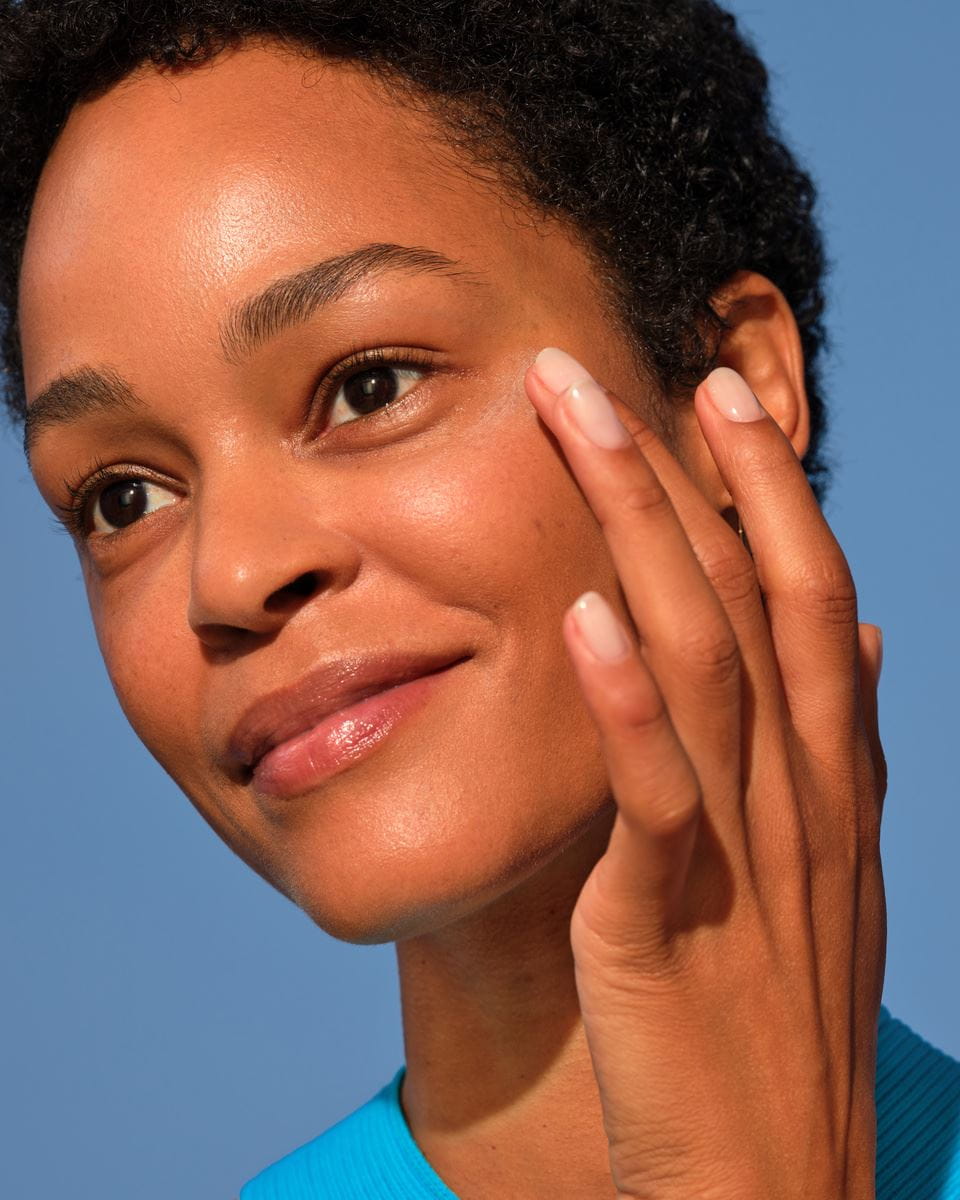 femme mettant de la crème pour les yeux sous les yeux