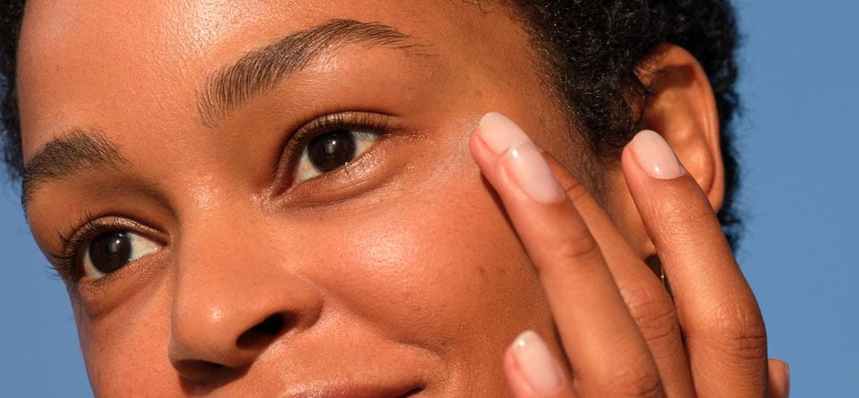 vrouw die oogcrème aanbrengt