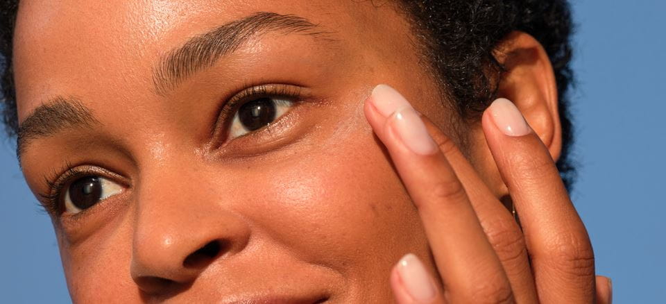 femme appliquant une crème contour des yeux