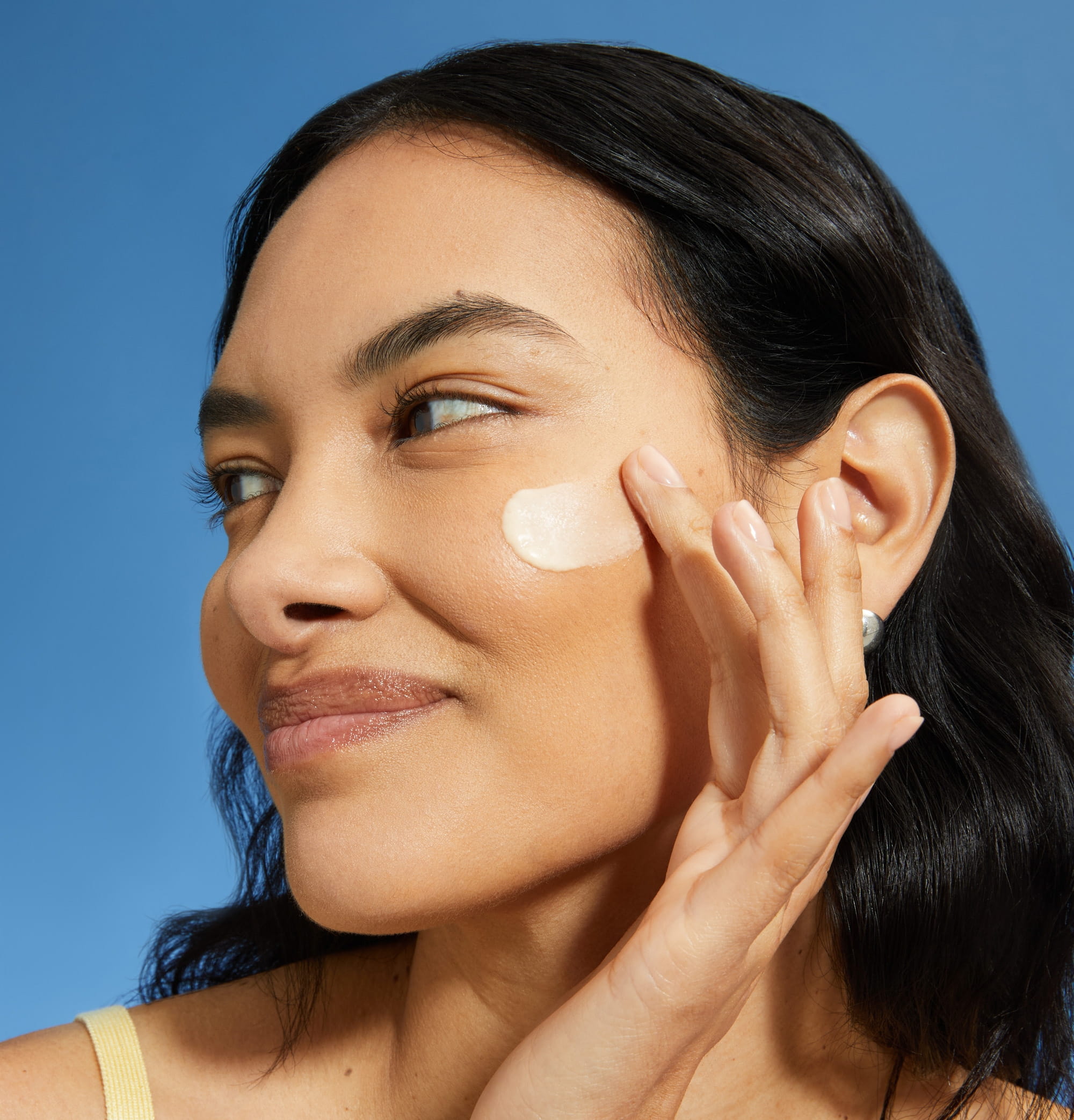 Frau trägt Sonnenschutzmittel auf