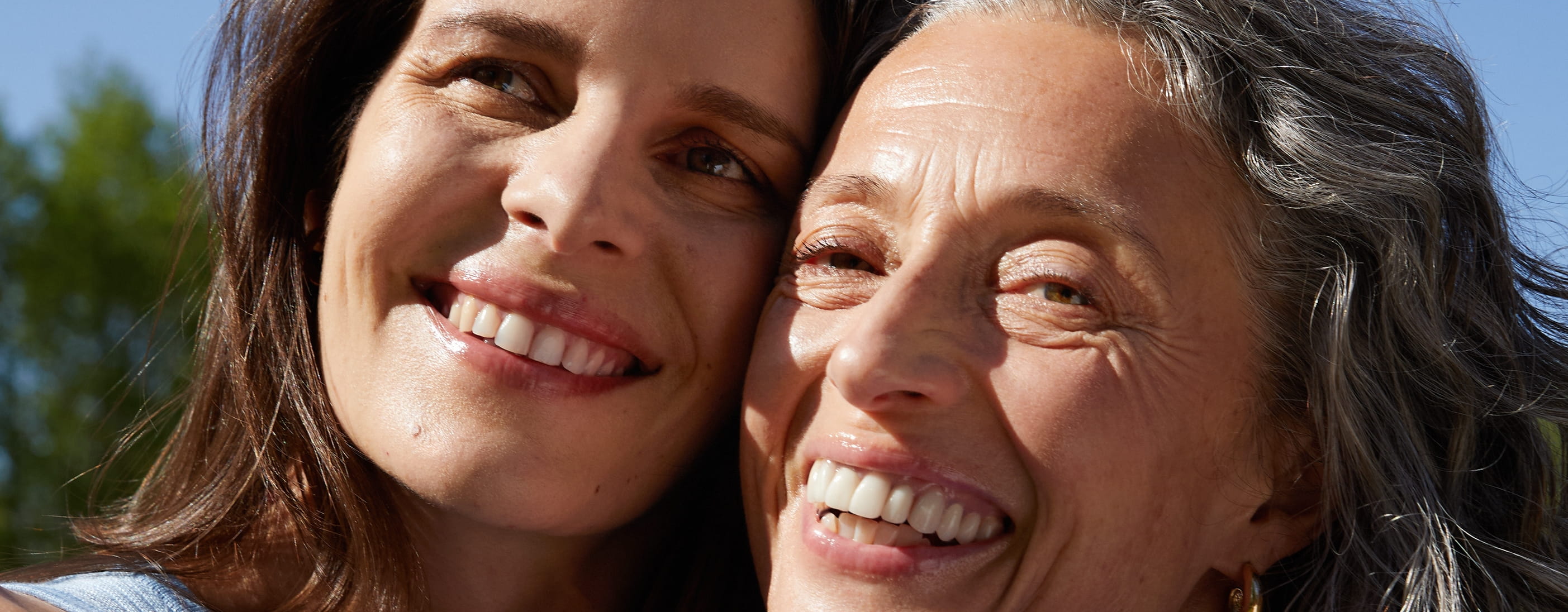 Två kvinnor håller om varandra och skrattar