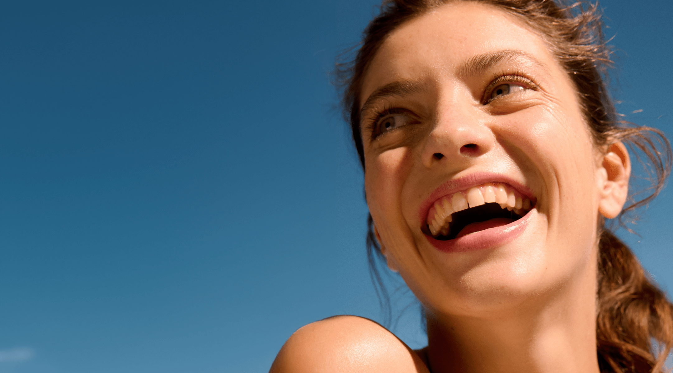 cheveux blonds femme tenant une crème pour le visage Nivea Q10