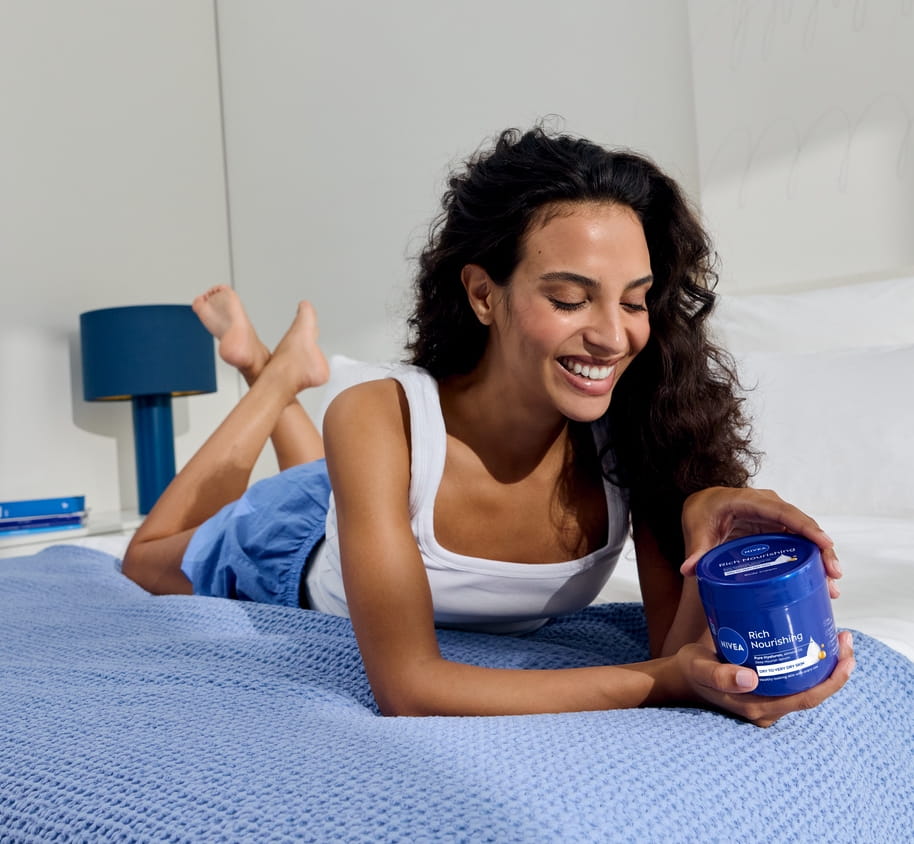 Young woman using Nivea Rich Nourishing body cream