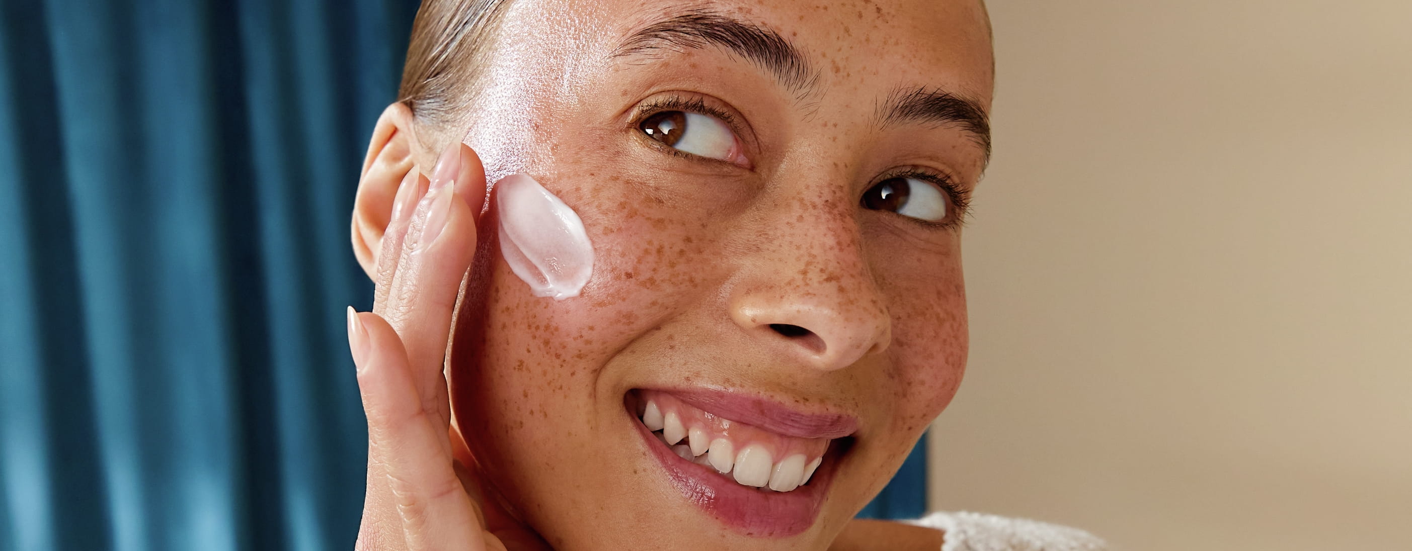 Tjej ler och har ansiktskräm på kinden