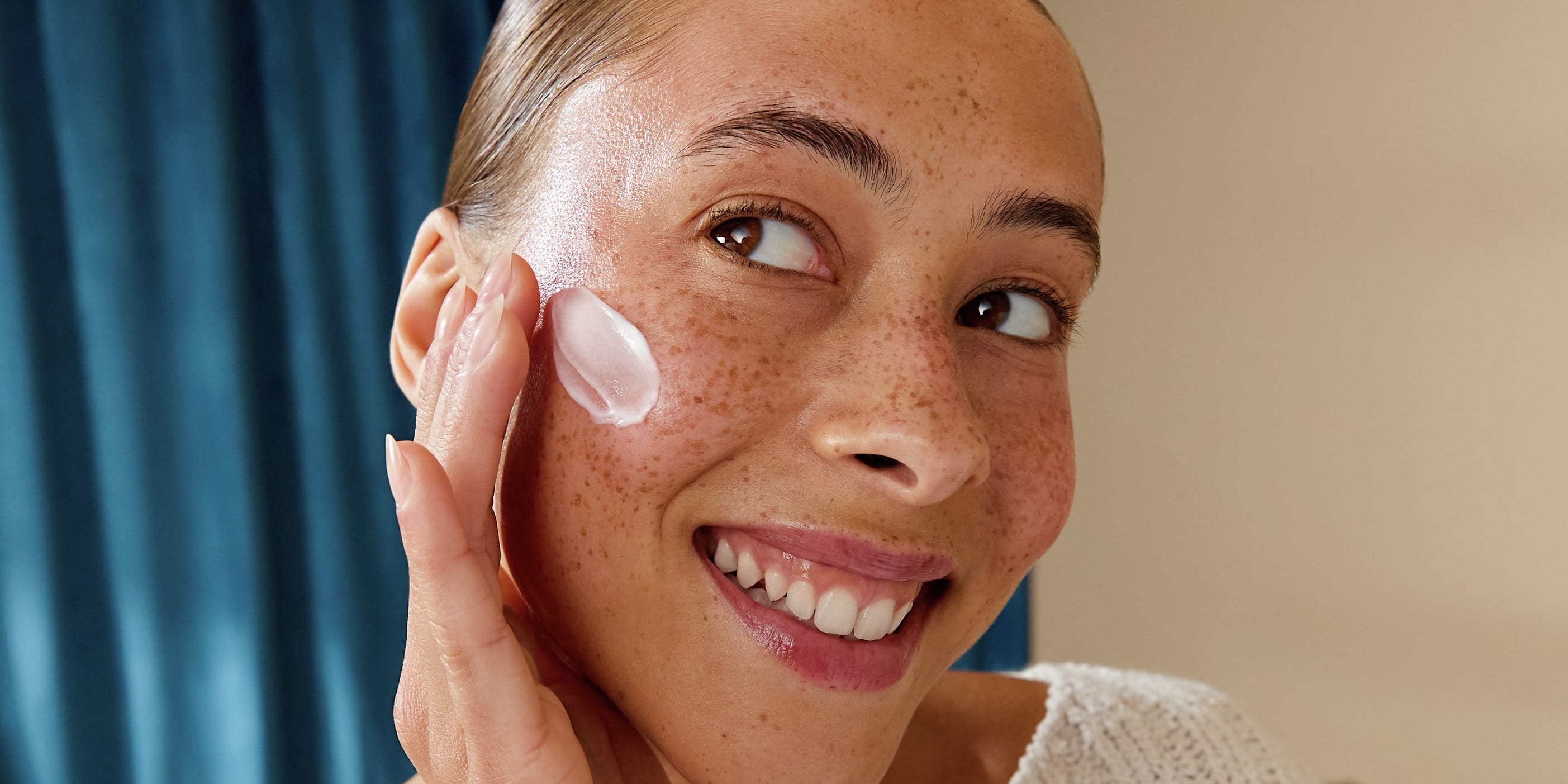 kvinna som applicerar fuktkräm i ansiktet